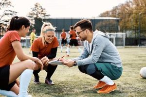 Sports coach talking to players