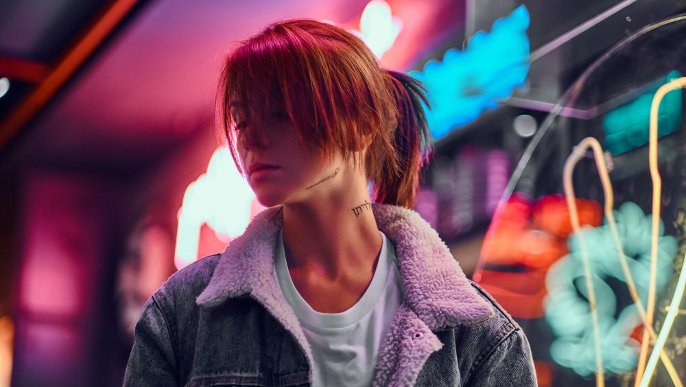 Woman in front of neon lights at night.