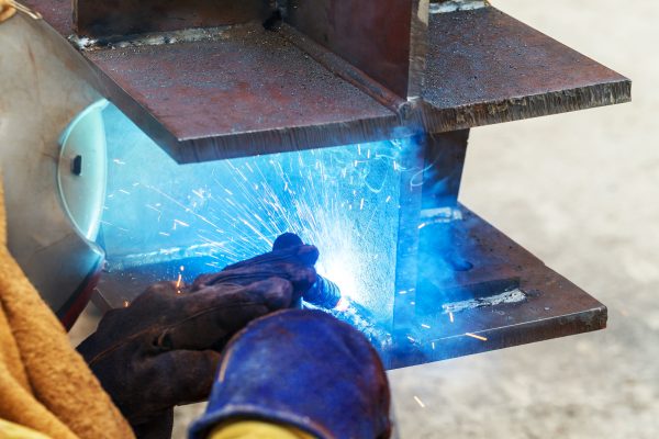 Person welding large metal plates.