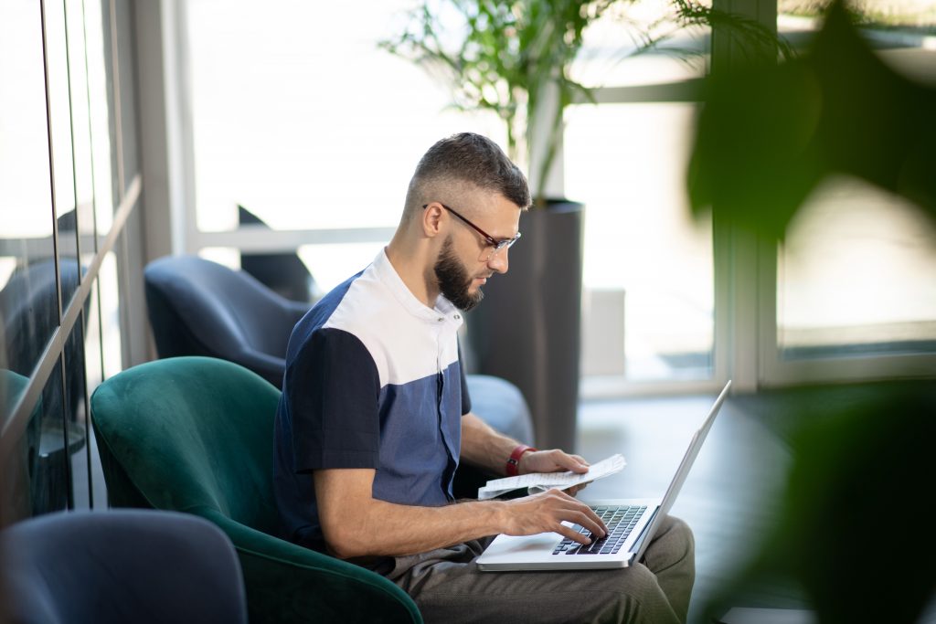 Man using laptop to do accounts.