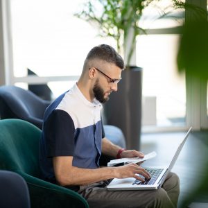 Man using laptop to do accounts.