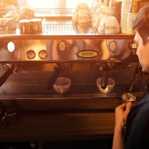 Man at barista coffee machine