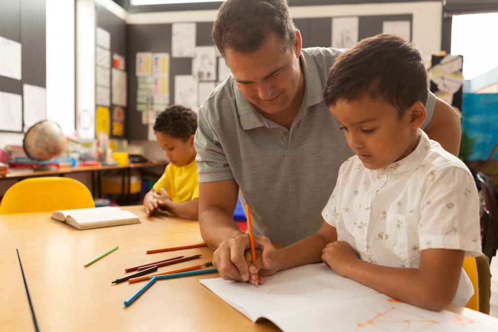 Man teaching child to write.