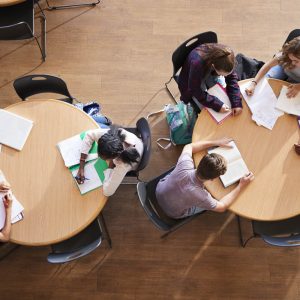 Overhead photo of students at round tables studying.