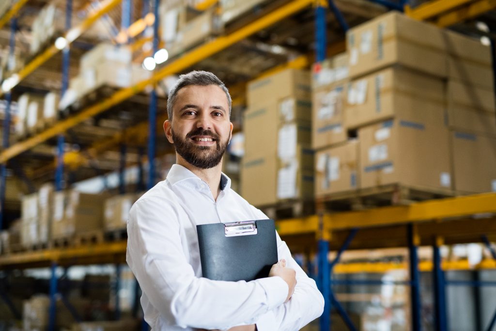 Man holding folder in warehouse.