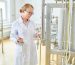 Woman wear lab coat inspecting food/liquid tank.