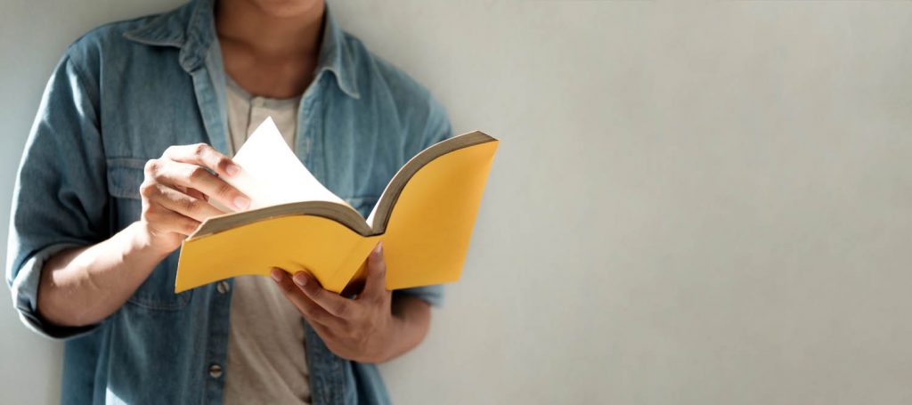 Cropped image of person reading a book.