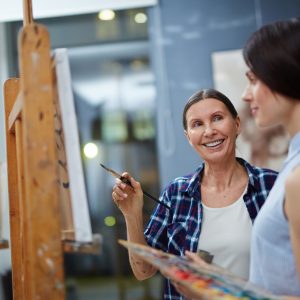 Artist teaching student to paint.