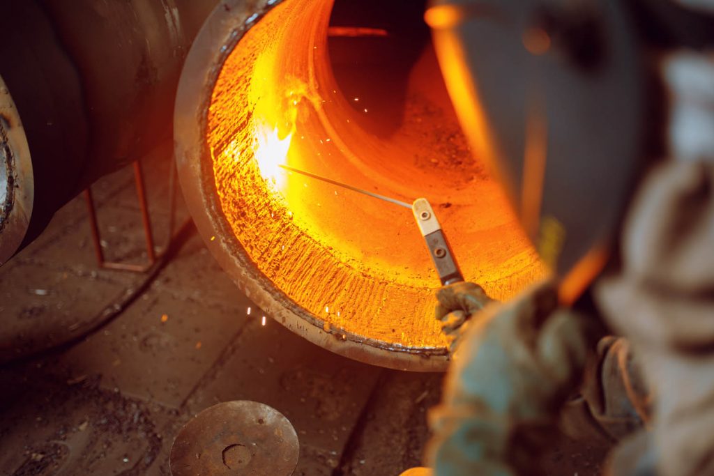 Person welding inside of pipe.