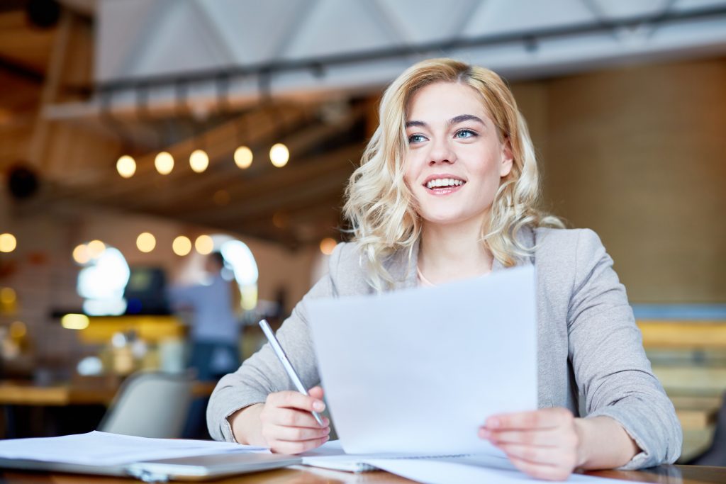 Woman with paperwork at table.