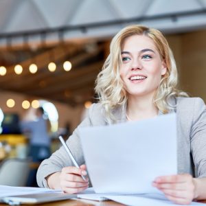 Woman with paperwork at table.