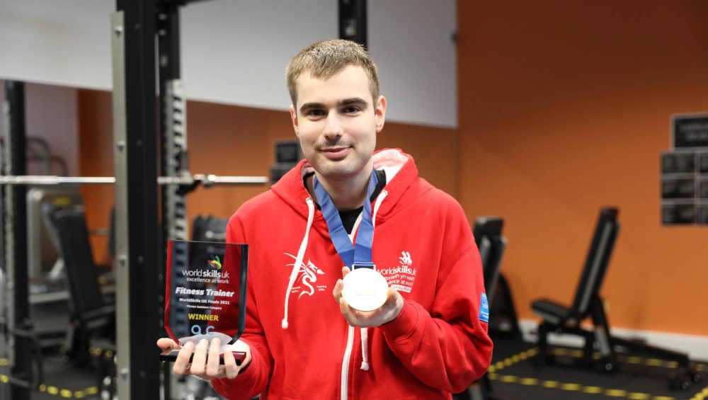 Kyle holding medal and trophy.