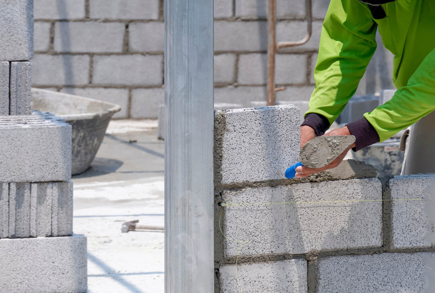 Person using trowel to lay concrete bricks
