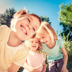 Three children smiling in the sun