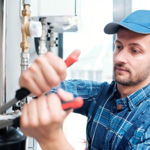 Plumber fixing pipes with wrench