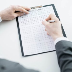 Person completing a multiple choice answer sheet