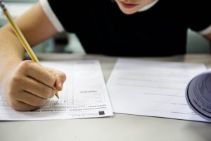Person completing multiple choice answer sheet