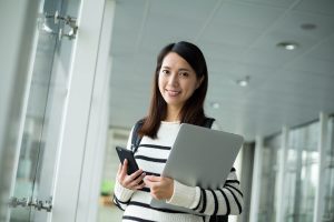 Perosn holding phone and laptop