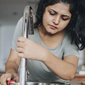 Plumber fixing a tap with a wrench