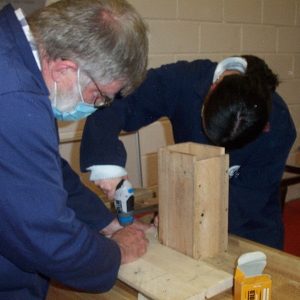 Two people working in carpentry workshop