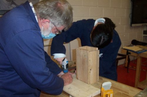 Two people working in carpentry workshop