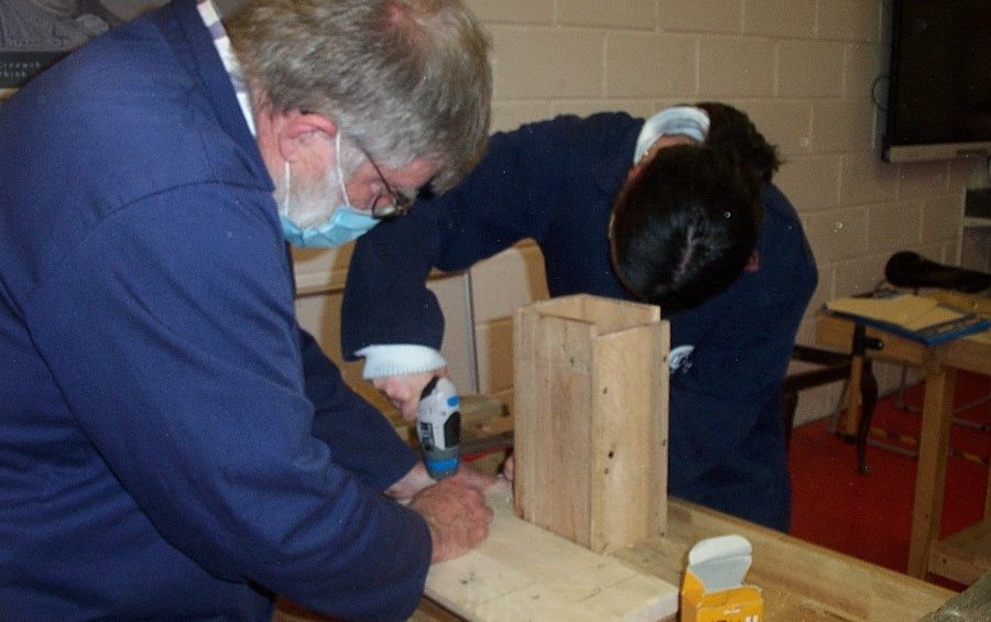 Two people working in carpentry workshop