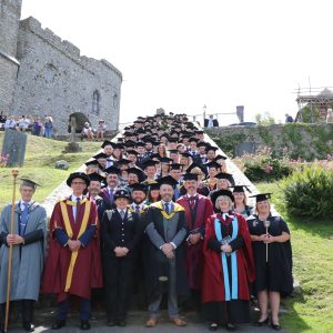 Group of staff and students at graduation on steps