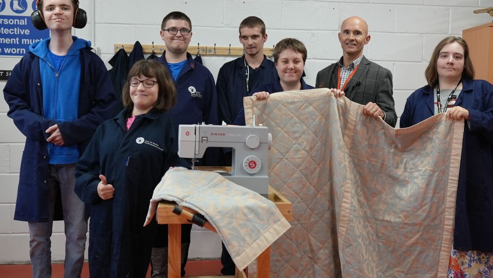 Staff and students holding up cycled blankets.