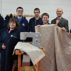 Staff and students holding up cycled blankets.