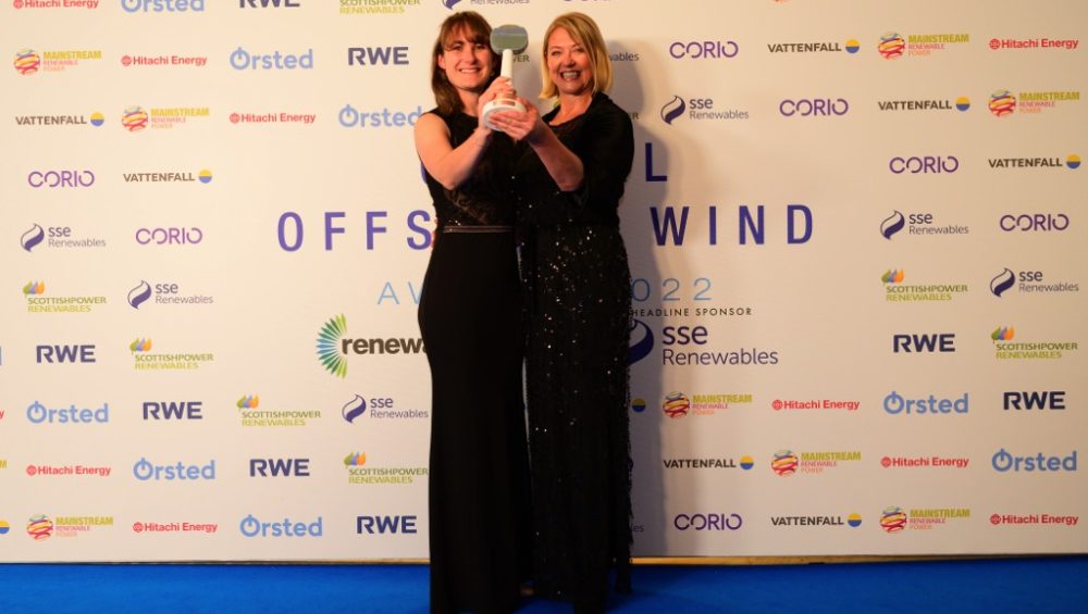 Two staff members holding award.