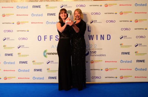 Two staff members holding award.