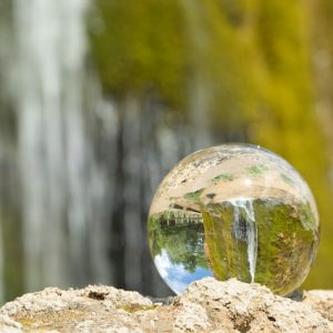 Glass globe in front of waterfall