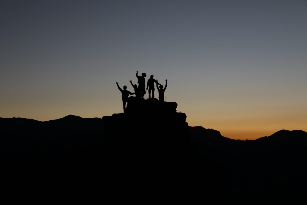 silhouette of people on mountain top