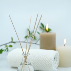 Reed difuser and candles on white background