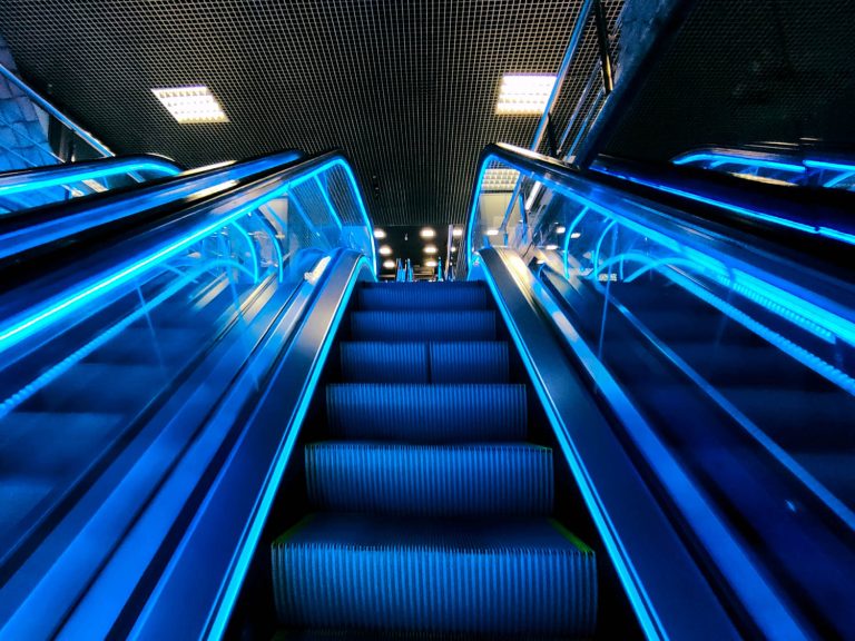 View of escalator at night with neon blue lights