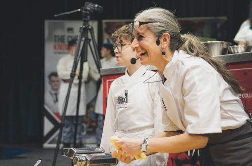 Chef and student demonstrating cooking skills.