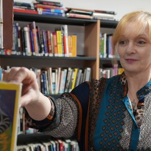 Pembrokeshire College Lecturer Sarah looking at books in the College Library