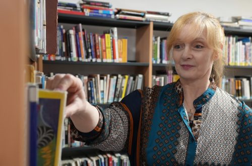 Pembrokeshire College Lecturer Sarah looking at books in the College Library