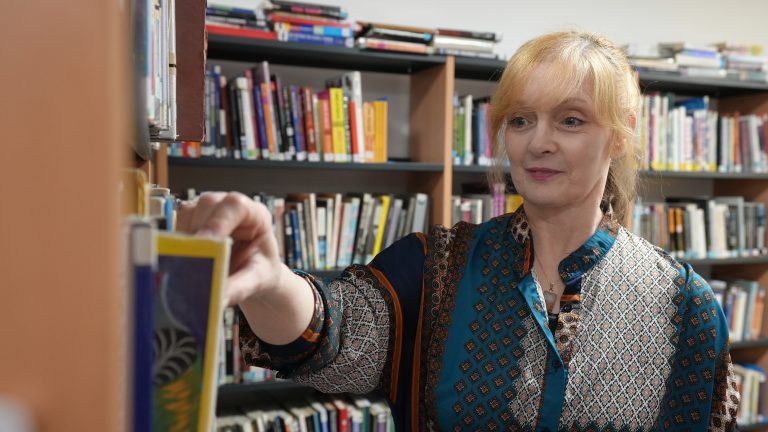 Pembrokeshire College Lecturer Sarah looking at books in the College Library