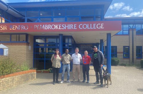 Dogs 4 Wildlife team with Pembrokeshire College Animal Care Tutors outside the College building.
