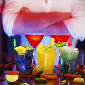 Mixologist standing behind a selection of cocktails