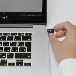 hand plugging in usb to side of laptop