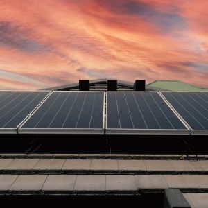 Solar roof power plant on the roof of a residential building with sunrise behind.