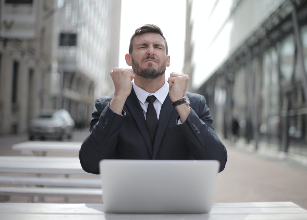 frustrated man in front of laptop outside