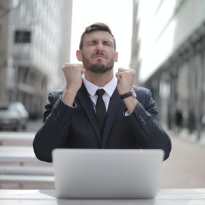 frustrated man in front of laptop outside