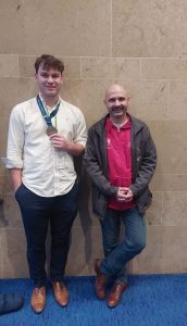 Staff and students holding medal