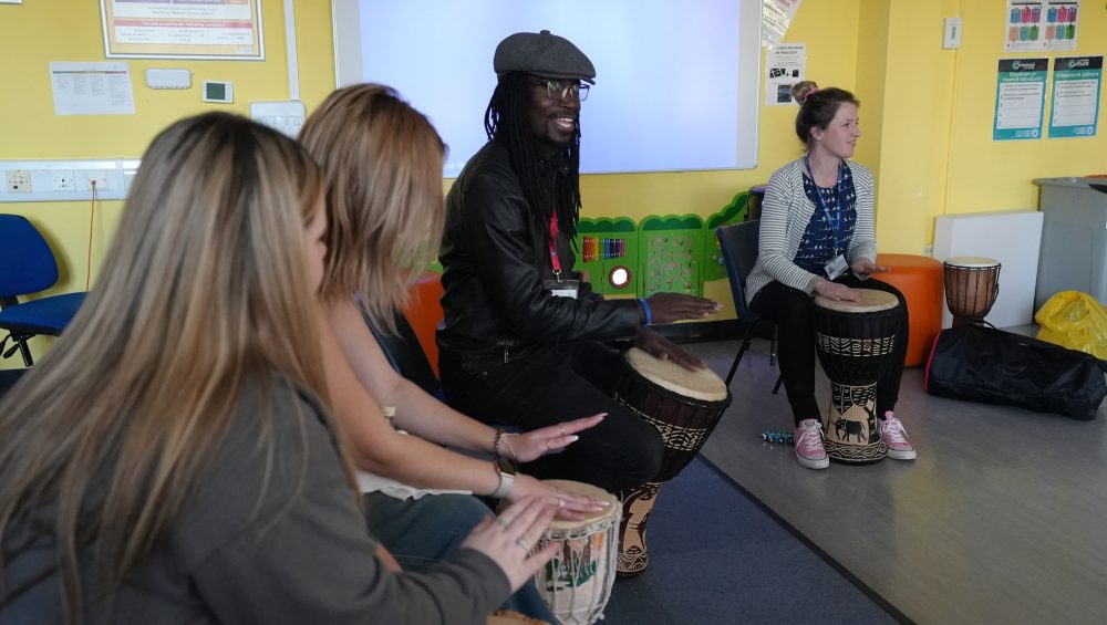 Lox with childcare learners patting on drums