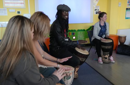 Lox with childcare learners patting on drums