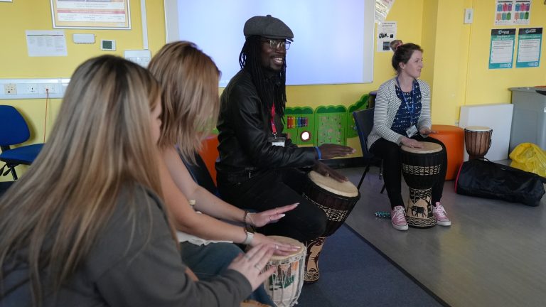 Lox with childcare learners patting on drums