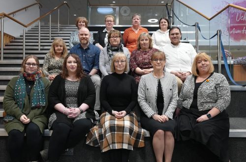 Group of staff sitting on steps.